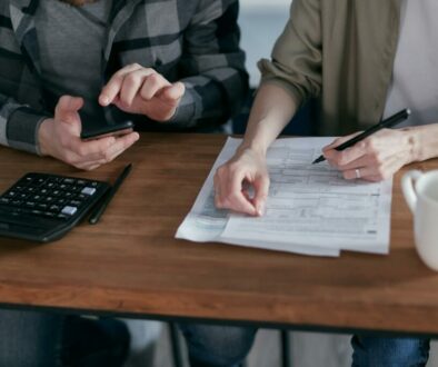 two people doing paperwork and computing taxes